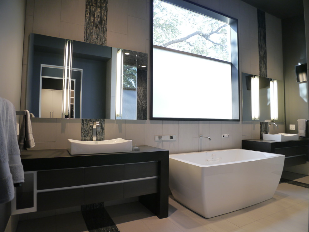 Idéer för ett modernt en-suite badrum, med ett fristående handfat, släta luckor, granitbänkskiva, ett fristående badkar, en öppen dusch, en toalettstol med hel cisternkåpa, grå kakel, porslinskakel, grå väggar och klinkergolv i porslin