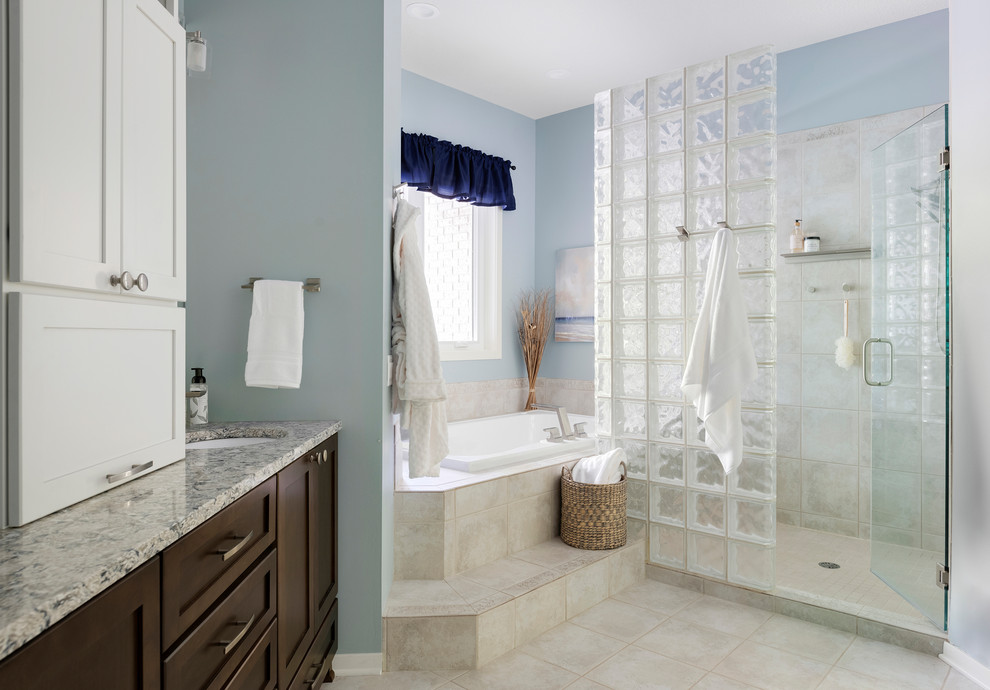 Large classic ensuite bathroom in Minneapolis with flat-panel cabinets, dark wood cabinets, a built-in bath, a double shower, a one-piece toilet, beige tiles, ceramic tiles, blue walls, ceramic flooring, a submerged sink, engineered stone worktops, beige floors, a hinged door and grey worktops.