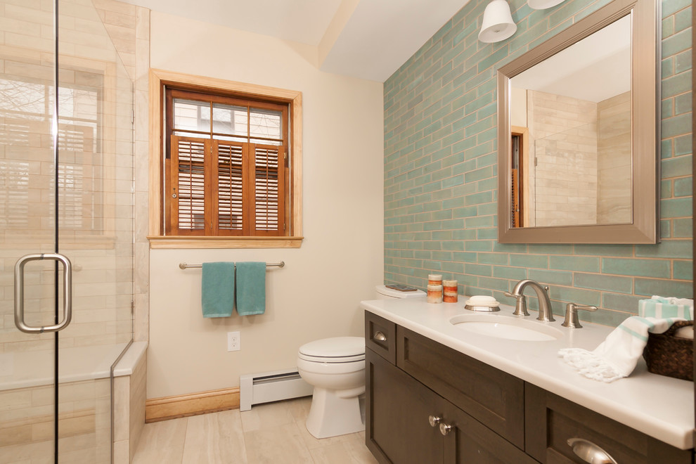 Modern inredning av ett badrum, med skåp i mörkt trä, blå kakel, keramikplattor, klinkergolv i keramik, ett undermonterad handfat, vitt golv och dusch med gångjärnsdörr