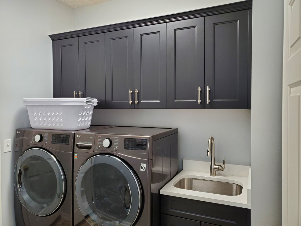 Immagine di una lavanderia moderna di medie dimensioni con ante lisce, ante marroni, pareti beige, pavimento in vinile e pavimento grigio