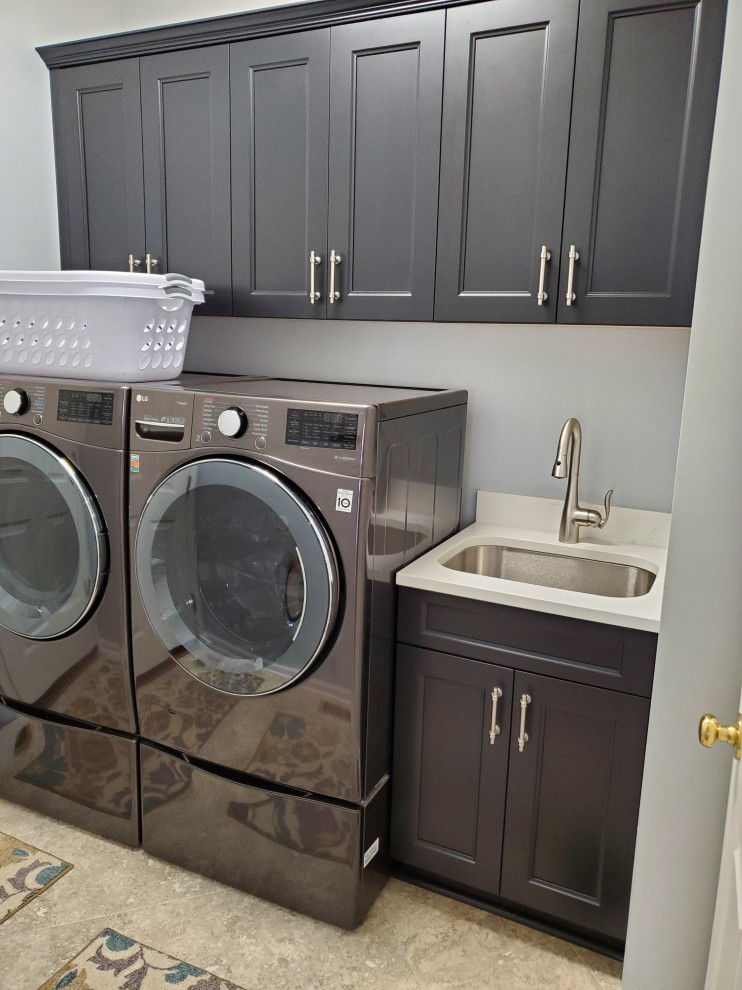 Modelo de lavadero minimalista de tamaño medio con armarios con paneles lisos, puertas de armario marrones, paredes beige, suelo vinílico y suelo gris