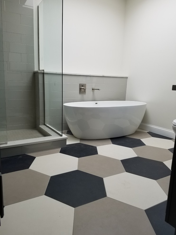 Large modern ensuite bathroom in Chicago with grey cabinets, a freestanding bath, an alcove shower, white tiles, grey walls, porcelain flooring, a submerged sink, engineered stone worktops, multi-coloured floors and a hinged door.