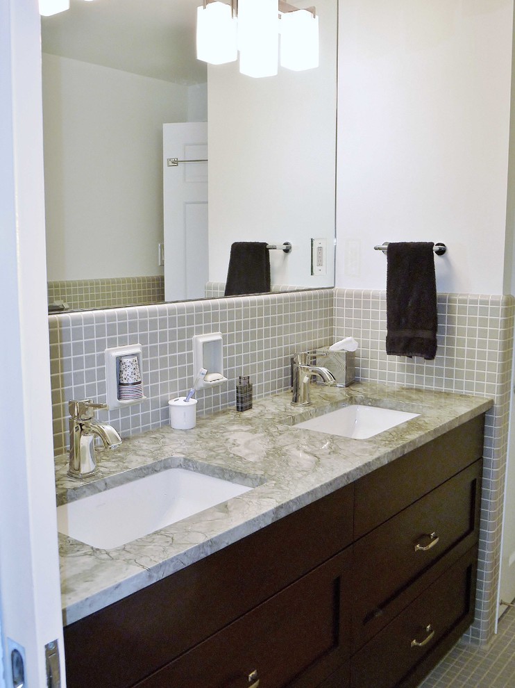 Cette photo montre une petite salle de bain principale moderne en bois foncé avec un lavabo encastré, un placard à porte plane, un plan de toilette en marbre, un carrelage gris, des carreaux de porcelaine et un mur blanc.