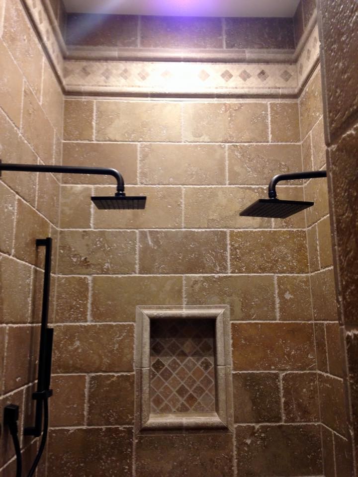 Immagine di una stanza da bagno padronale tradizionale con ante con bugna sagomata, ante in legno bruno, top in granito, vasca ad alcova, piastrelle beige, piastrelle in pietra e pavimento in cemento