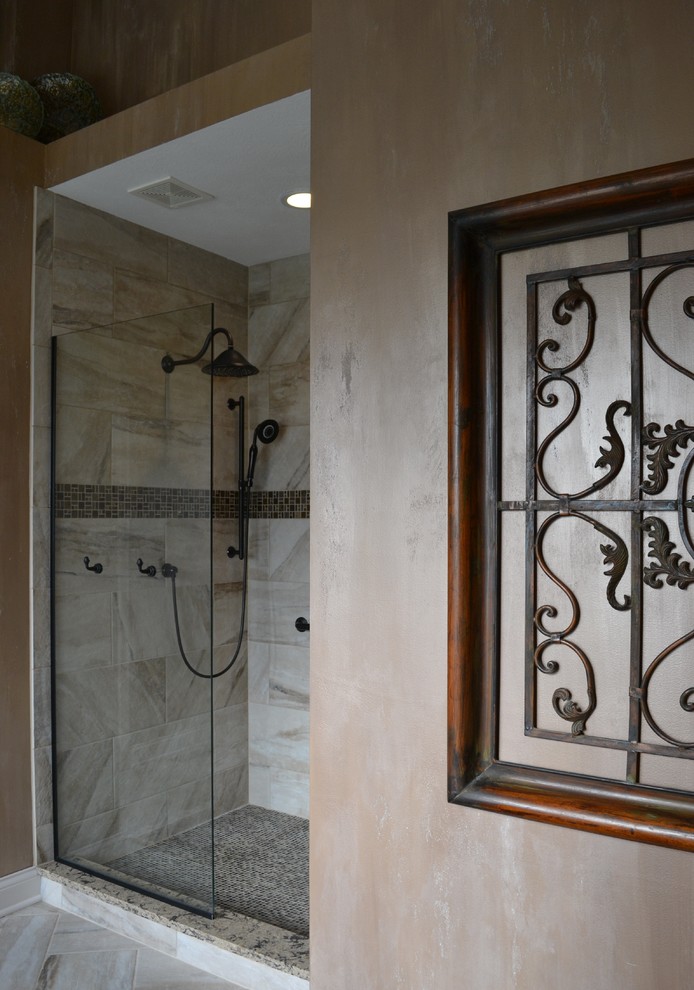 Inredning av ett klassiskt en-suite badrum, med ett undermonterad handfat, luckor med upphöjd panel, skåp i mellenmörkt trä, granitbänkskiva, ett hörnbadkar, en dusch i en alkov, flerfärgad kakel, stenkakel, bruna väggar och klinkergolv i porslin