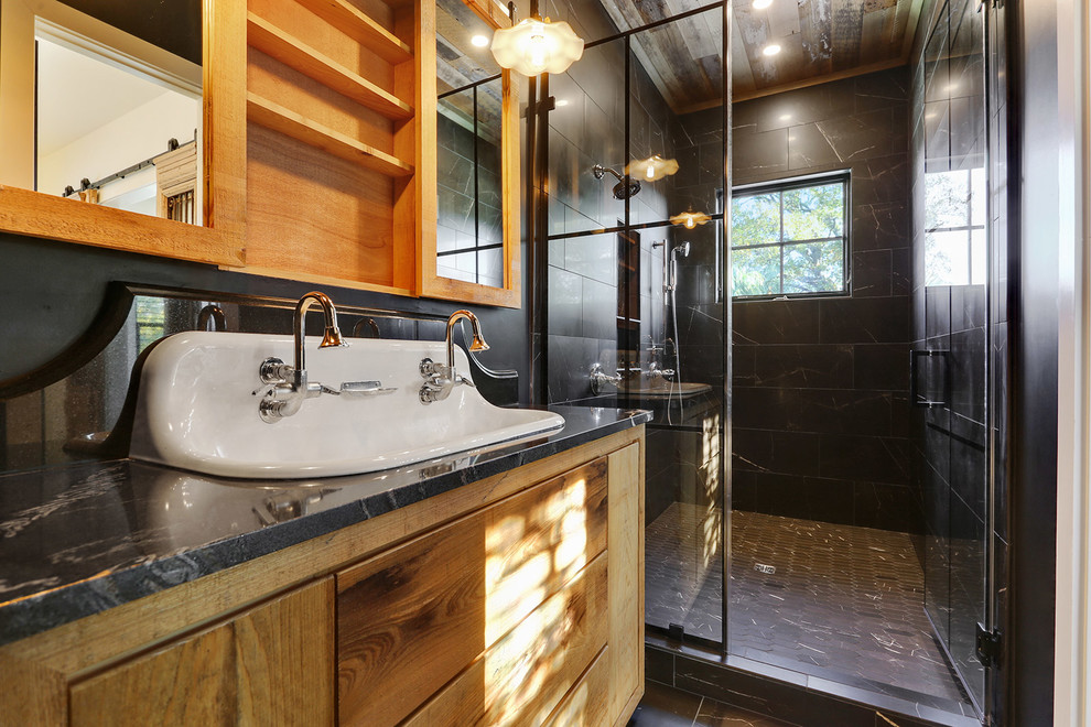 Small farmhouse ensuite bathroom in New Orleans with freestanding cabinets, distressed cabinets, a double shower, black tiles, ceramic tiles, black walls, porcelain flooring, a trough sink, granite worktops, black floors, a hinged door and black worktops.