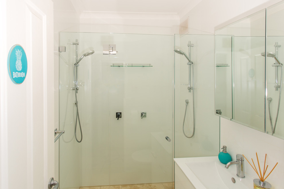 Kleines Maritimes Badezimmer mit flächenbündigen Schrankfronten, weißen Schränken, Doppeldusche, weißen Fliesen, Keramikfliesen, weißer Wandfarbe und Travertin in Sydney