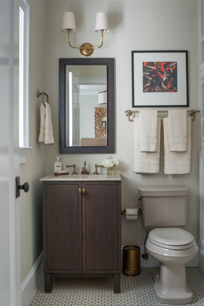 Exemple d'une petite salle d'eau craftsman en bois brun avec un lavabo intégré, WC séparés, un carrelage blanc, un mur beige, un sol en carrelage de céramique, un plan de toilette en surface solide, des carreaux de céramique et un placard à porte plane.