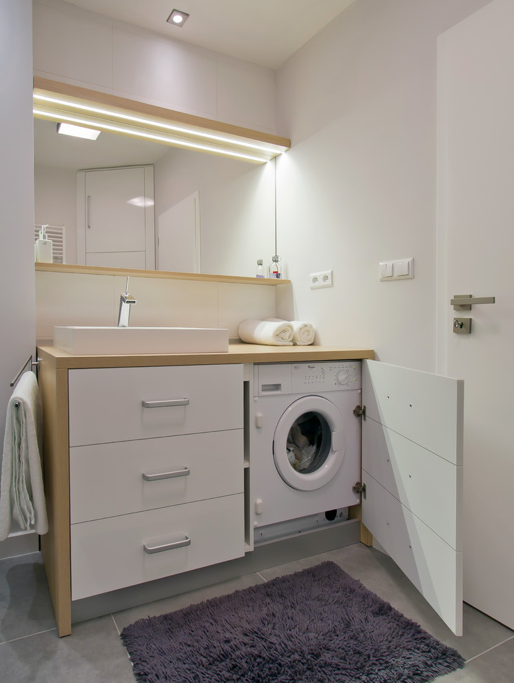 На фото: ванная комната со стиральной машиной в стиле модернизм с настольной раковиной с