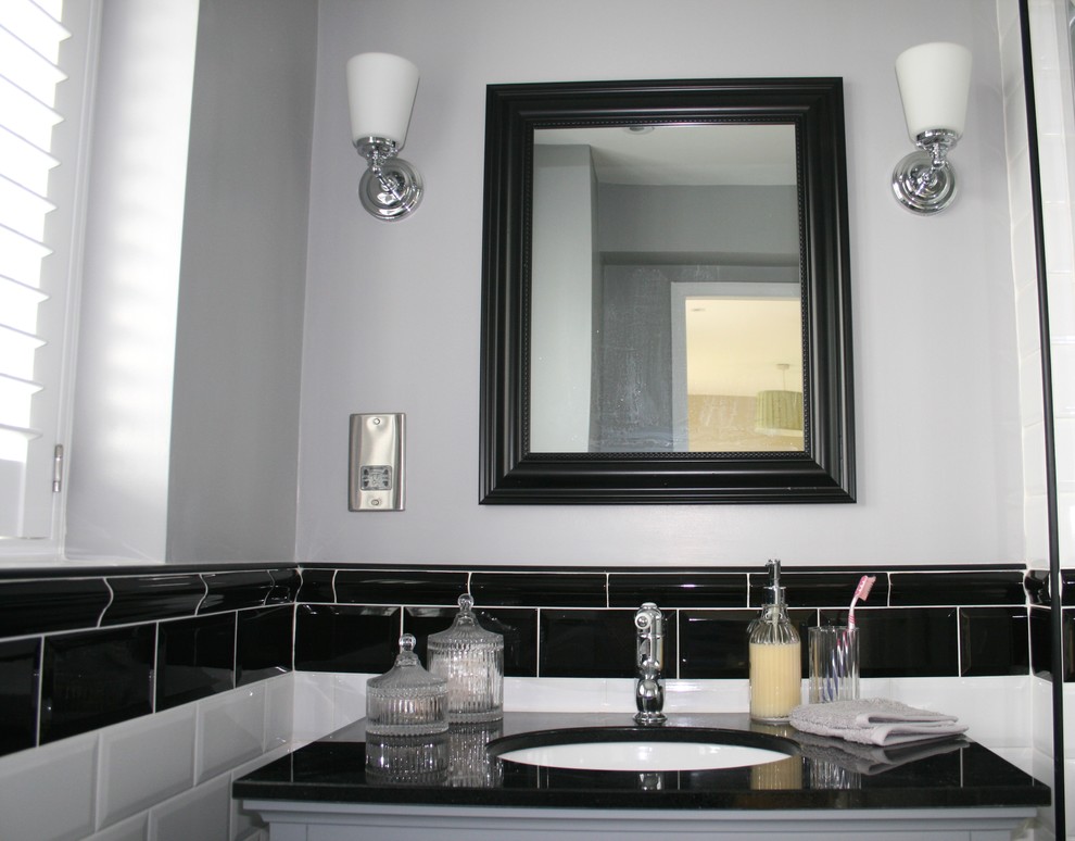This is an example of a small classic family bathroom in Other with shaker cabinets, grey cabinets, a corner shower, a one-piece toilet, black and white tiles, porcelain tiles, grey walls, ceramic flooring, a submerged sink and granite worktops.