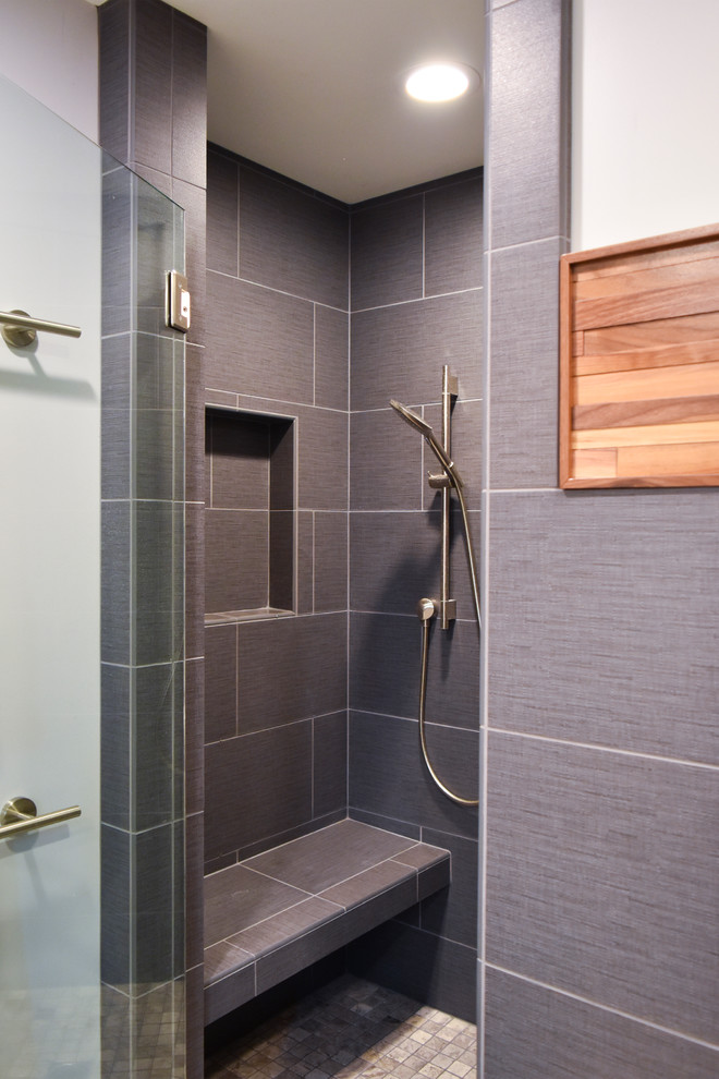 Inredning av ett modernt mellanstort en-suite badrum, med släta luckor, ett fristående badkar, en öppen dusch, en toalettstol med separat cisternkåpa, blå kakel, porslinskakel, grå väggar, betonggolv, ett fristående handfat, marmorbänkskiva och skåp i mellenmörkt trä