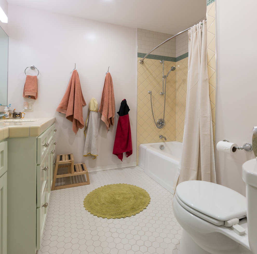 На фото: ванная комната в стиле неоклассика (современная классика) с фасадами в стиле шейкер, зелеными фасадами, желтой плиткой, белыми стенами, полом из мозаичной плитки, столешницей из плитки, белым полом и шторкой для ванной с