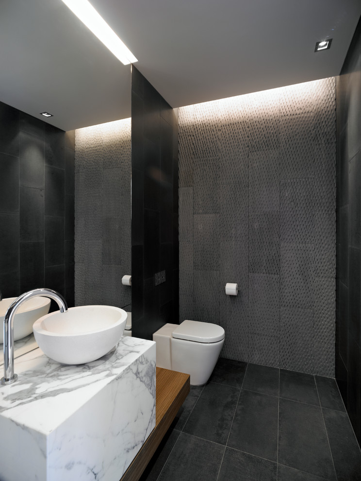Esempio di una stanza da bagno design con vasca freestanding, WC monopezzo, piastrelle grigie e lavabo a colonna