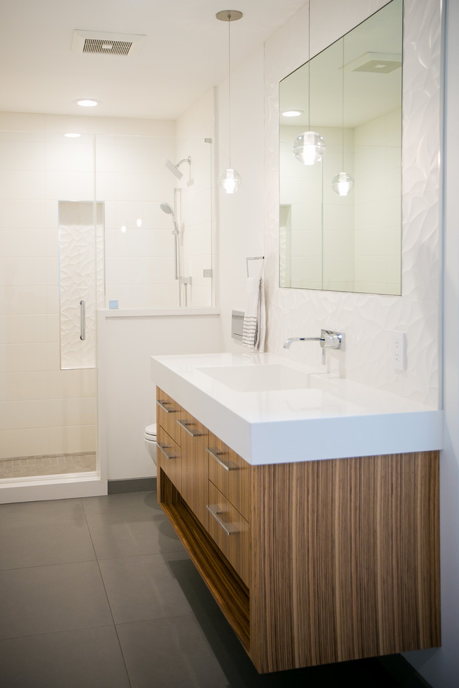 This is an example of a large contemporary shower room bathroom in San Francisco with flat-panel cabinets, medium wood cabinets, an alcove shower, a wall mounted toilet, white tiles, ceramic tiles, white walls, porcelain flooring, an integrated sink and engineered stone worktops.