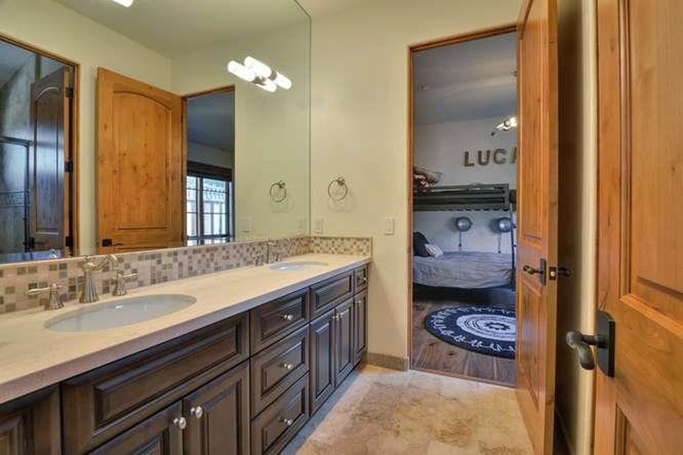 Expansive rustic family bathroom in San Francisco with raised-panel cabinets, dark wood cabinets, a built-in bath, an alcove shower, a two-piece toilet, beige tiles, white walls, a submerged sink and granite worktops.