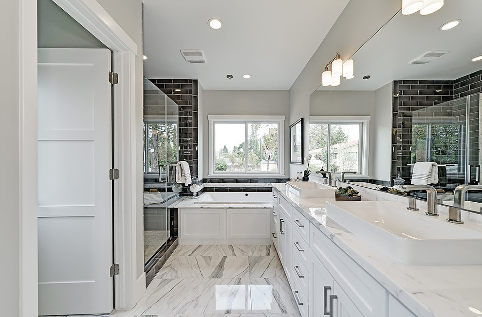 Aménagement d'une douche en alcôve principale classique avec un placard à porte shaker, des portes de placard blanches, une baignoire en alcôve, un carrelage blanc, un mur gris, un sol en marbre et un plan de toilette en marbre.