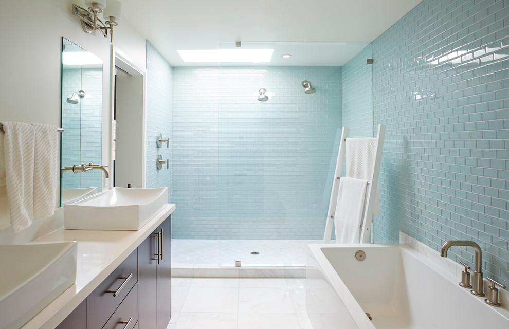 Photo of a modern ensuite bathroom in Phoenix with flat-panel cabinets, medium wood cabinets, a corner bath, a double shower, blue tiles, white walls, marble flooring, a vessel sink and engineered stone worktops.