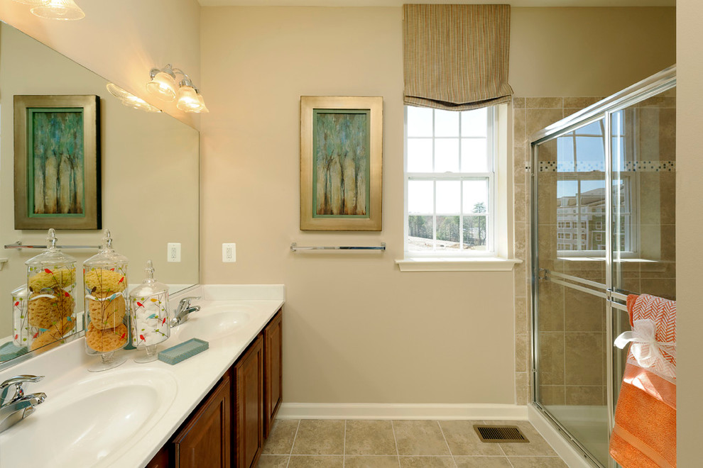 Large elegant master beige tile and ceramic tile ceramic tile walk-in shower photo in Baltimore with a console sink, raised-panel cabinets, medium tone wood cabinets, solid surface countertops and beige walls