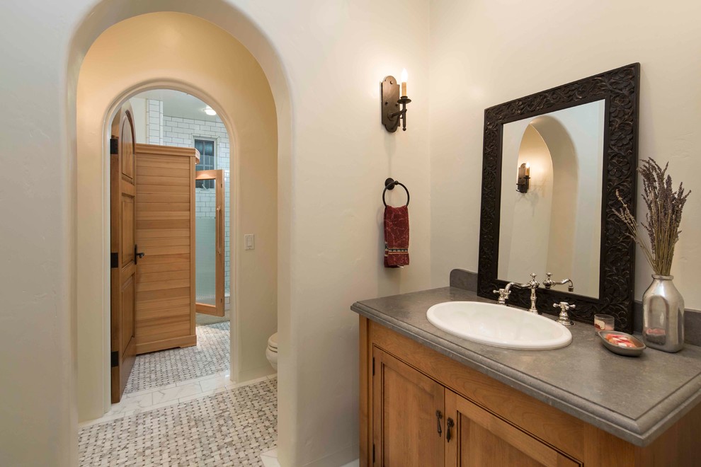 Inspiration for a large mediterranean ensuite bathroom in Santa Barbara with recessed-panel cabinets, medium wood cabinets, a walk-in shower, a two-piece toilet, metro tiles, white walls, mosaic tile flooring and a built-in sink.