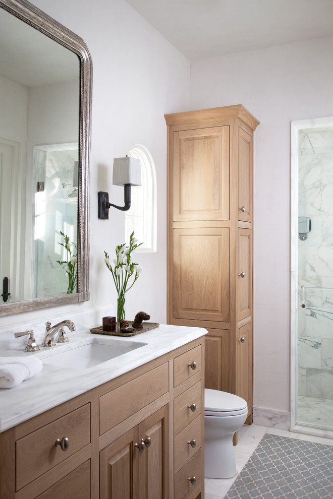 Esempio di una stanza da bagno mediterranea con lavabo sottopiano, ante con bugna sagomata, ante in legno scuro, doccia alcova, piastrelle bianche e pareti bianche