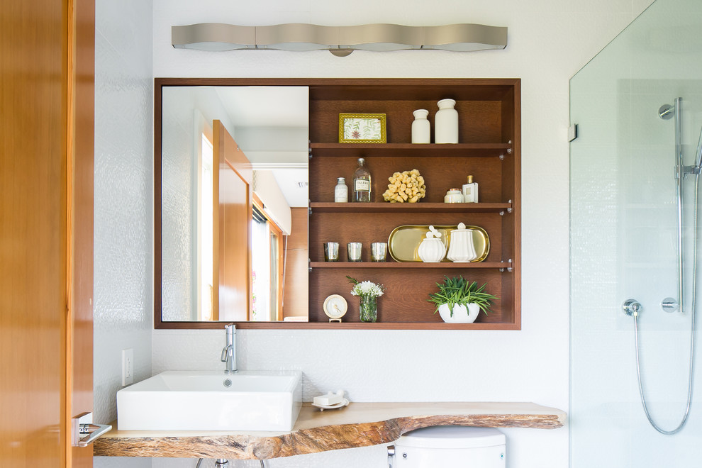 Foto di una stanza da bagno con doccia moderna con piastrelle bianche, piastrelle di vetro, pareti bianche, lavabo a bacinella, top in legno e top marrone