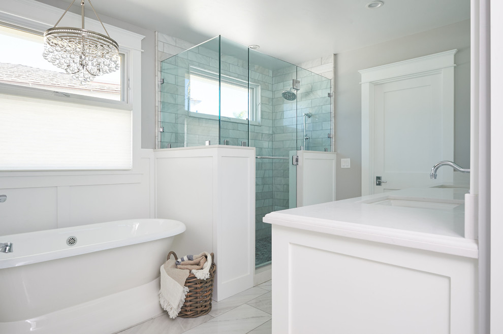 Bild på ett stort maritimt vit vitt en-suite badrum, med skåp i shakerstil, vita skåp, ett fristående badkar, en hörndusch, vit kakel, marmorkakel, grå väggar, marmorgolv, ett undermonterad handfat, marmorbänkskiva, vitt golv och dusch med gångjärnsdörr