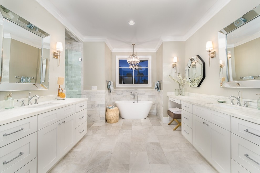 This is an example of a large traditional ensuite half tiled bathroom in Phoenix with recessed-panel cabinets, white cabinets, a freestanding bath, an alcove shower, stone tiles, beige walls, a submerged sink and a hinged door.