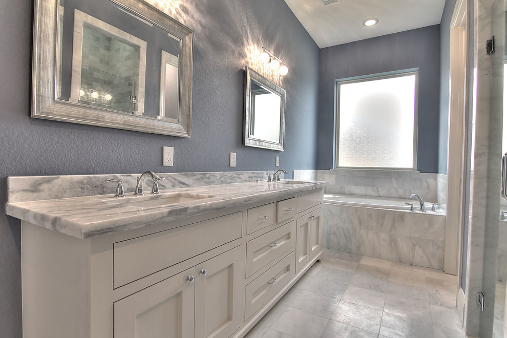 Bathroom - mid-sized traditional 3/4 gray tile, white tile and porcelain tile porcelain tile and white floor bathroom idea in Houston with shaker cabinets, white cabinets, gray walls, an undermount sink, marble countertops and a hinged shower door