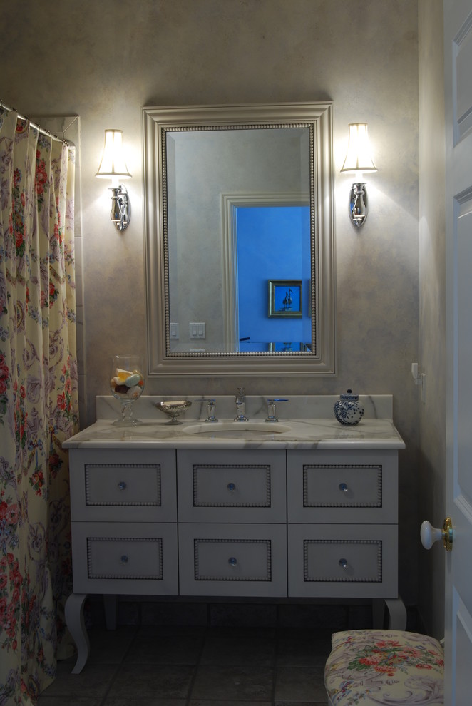 Exemple d'une salle de bain chic de taille moyenne avec un placard à porte plane, des portes de placard grises, un carrelage beige, des carreaux de porcelaine, un mur multicolore, un plan de toilette en marbre, parquet foncé et un lavabo encastré.