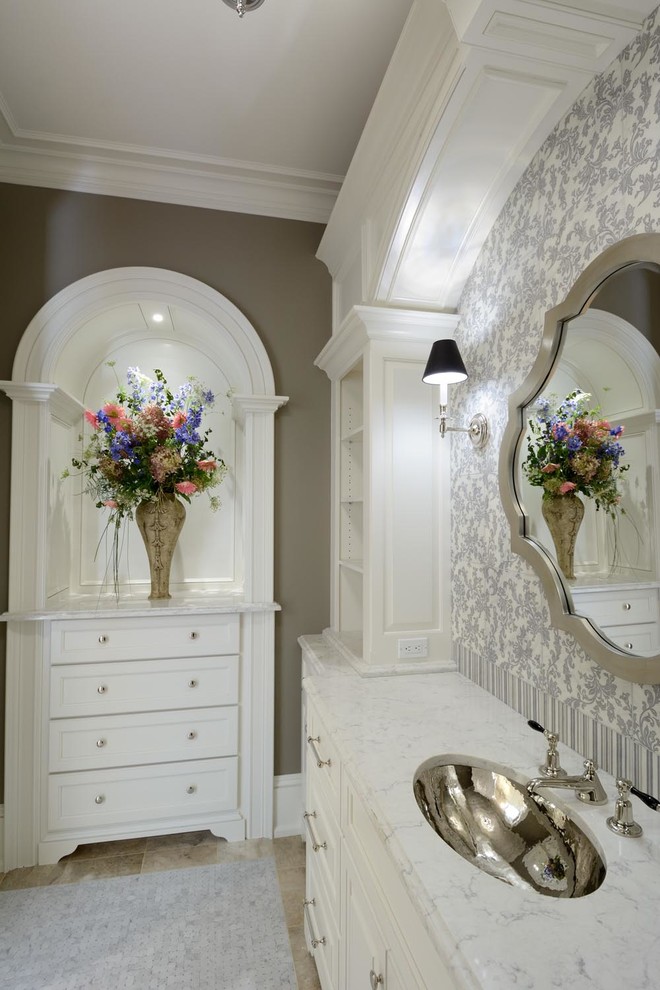 Exemple d'une grande salle de bain chic avec des portes de placard blanches, un mur marron, un sol en marbre, un lavabo encastré et un plan de toilette en marbre.