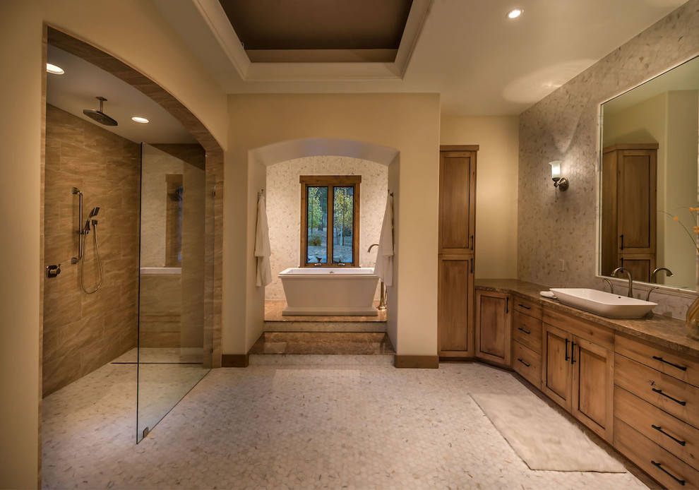 Example of a large transitional master beige tile ceramic tile bathroom design in Other with raised-panel cabinets, medium tone wood cabinets, beige walls, a vessel sink and marble countertops