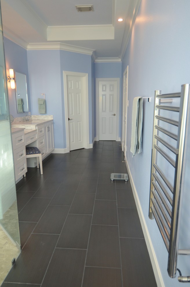 Bathroom - mid-sized contemporary master white tile and stone tile porcelain tile and brown floor bathroom idea in Houston with shaker cabinets, white cabinets, a two-piece toilet, blue walls, an undermount sink, quartz countertops and a hinged shower door