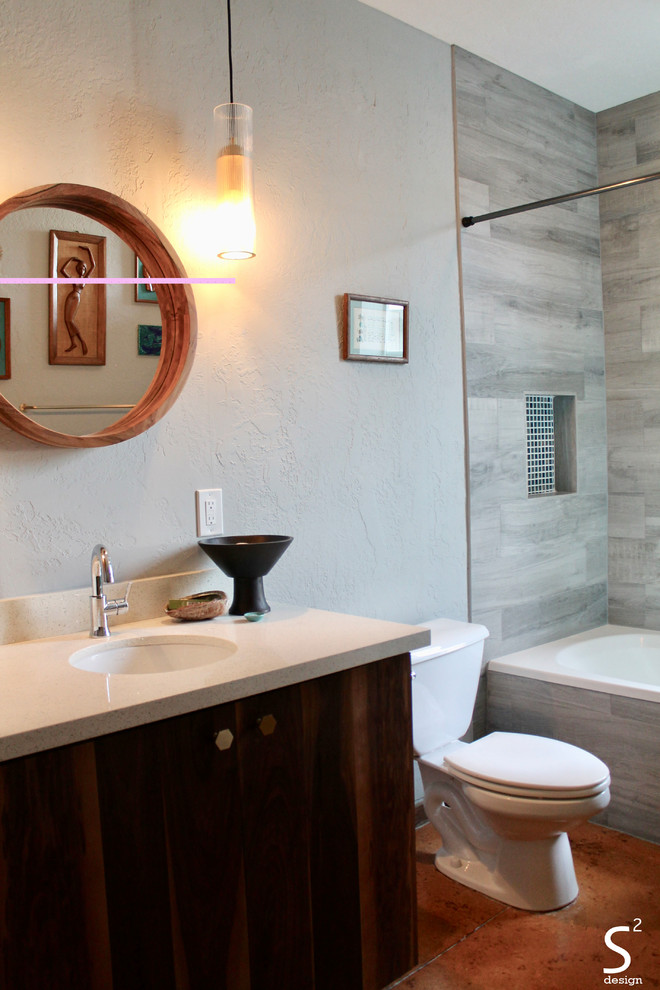 Пример оригинального дизайна: ванная комната среднего размера в стиле ретро с плоскими фасадами, фасадами цвета дерева среднего тона, ванной в нише, душем над ванной, раздельным унитазом, серой плиткой, керамогранитной плиткой, синими стенами, бетонным полом, врезной раковиной, столешницей из искусственного кварца, оранжевым полом, шторкой для ванной и белой столешницей
