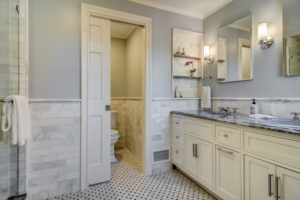 Double shower - large traditional master gray tile and marble tile marble floor and white floor double shower idea in Newark with beaded inset cabinets, white cabinets, a one-piece toilet, blue walls, an undermount sink, marble countertops, a hinged shower door and black countertops