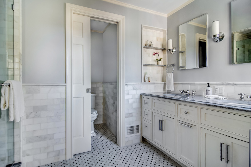 Example of a large classic master gray tile and marble tile marble floor and white floor double shower design in Newark with beaded inset cabinets, white cabinets, a one-piece toilet, blue walls, an undermount sink, marble countertops, a hinged shower door and black countertops