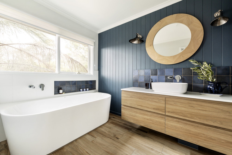 Diseño de cuarto de baño contemporáneo de tamaño medio con bañera exenta, ducha abierta, baldosas y/o azulejos azules, paredes azules, suelo de baldosas de cerámica, lavabo con pedestal, encimera de cuarzo compacto y encimeras blancas