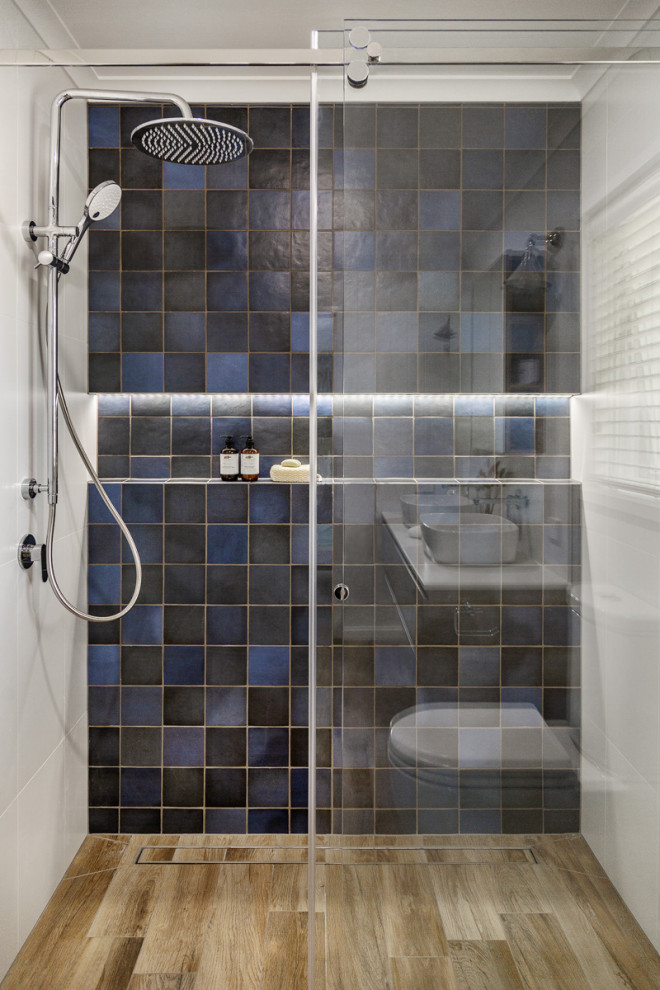 Idées déco pour une salle de bain contemporaine avec un carrelage bleu, un mur bleu, un sol en carrelage de céramique et une cabine de douche à porte coulissante.