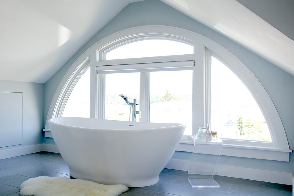 ポートランド(メイン)にある広いビーチスタイルのおしゃれなマスターバスルーム (フラットパネル扉のキャビネット、置き型浴槽、青い壁、磁器タイルの床) の写真