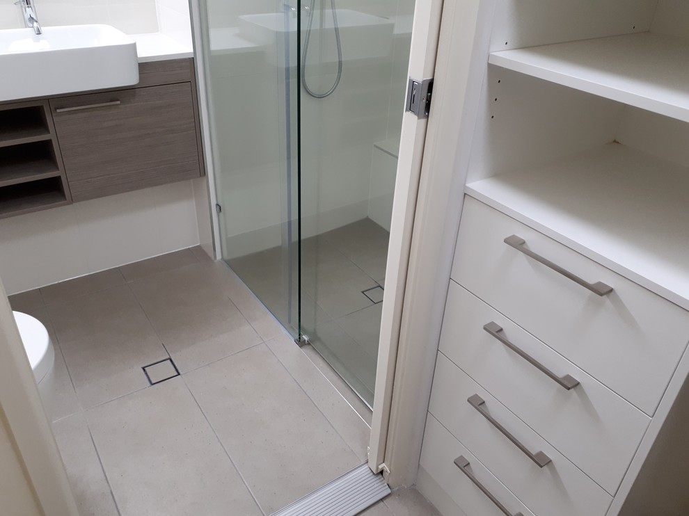 На фото: маленькая ванная комната в современном стиле с белой плиткой, керамической плиткой, белыми стенами, полом из цементной плитки, серым полом и душем с раздвижными дверями для на участке и в саду с