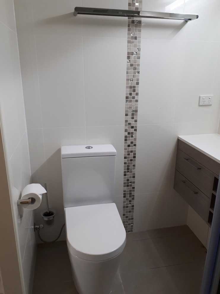 Cette photo montre une petite salle de bain tendance avec un carrelage blanc, des carreaux de céramique, un mur blanc, carreaux de ciment au sol, un sol gris et une cabine de douche à porte coulissante.