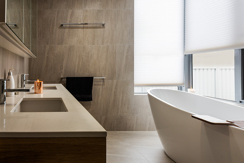 Inspiration för moderna grått badrum med dusch, med skåp i mellenmörkt trä, ett fristående badkar, grå kakel, grå väggar, ett undermonterad handfat, grått golv, stenkakel och en dubbeldusch