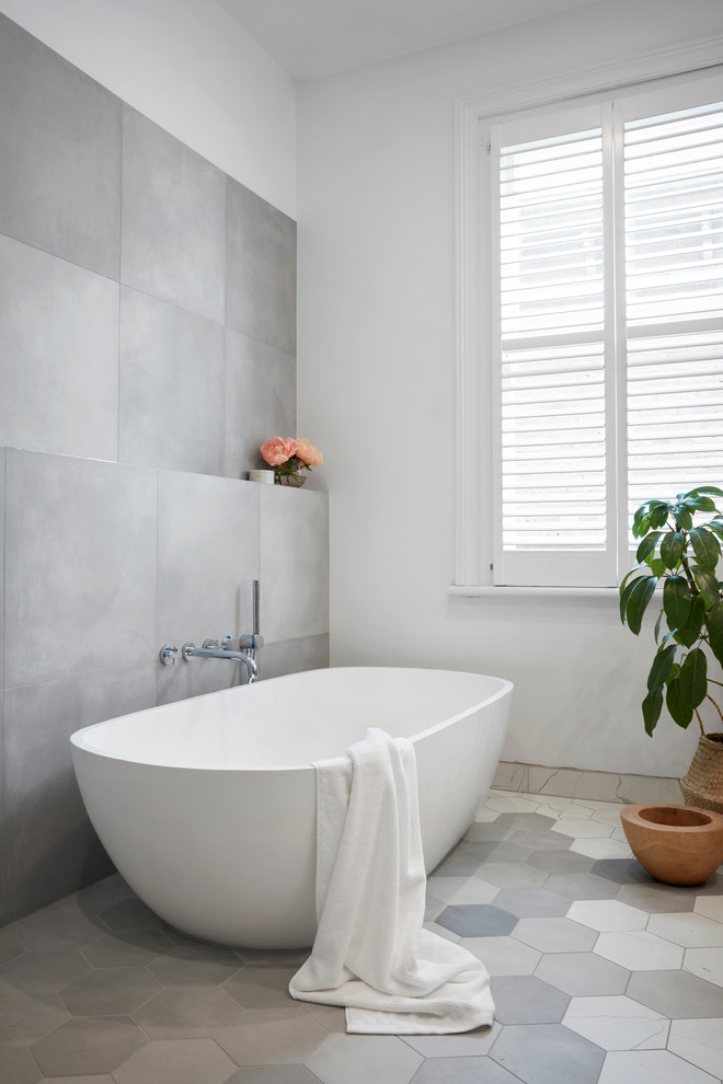 Design ideas for a large contemporary ensuite bathroom in Melbourne with flat-panel cabinets, light wood cabinets, a freestanding bath, a walk-in shower, grey tiles, white tiles, mosaic tiles, white walls, mosaic tile flooring, a vessel sink and solid surface worktops.
