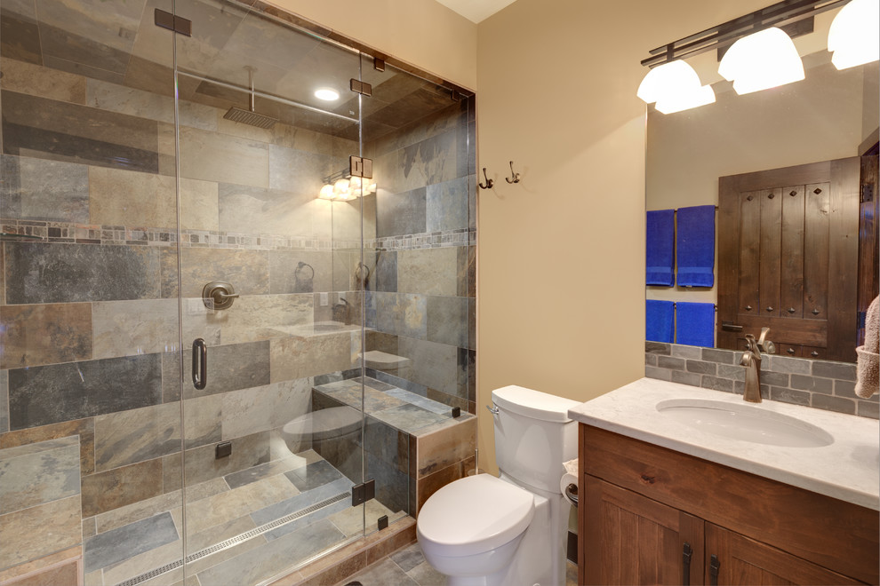 Design ideas for a rustic ensuite bathroom in Vancouver with beaded cabinets, medium wood cabinets, a double shower, a two-piece toilet, multi-coloured tiles, slate tiles, beige walls, slate flooring, a submerged sink, granite worktops, multi-coloured floors, a hinged door and white worktops.