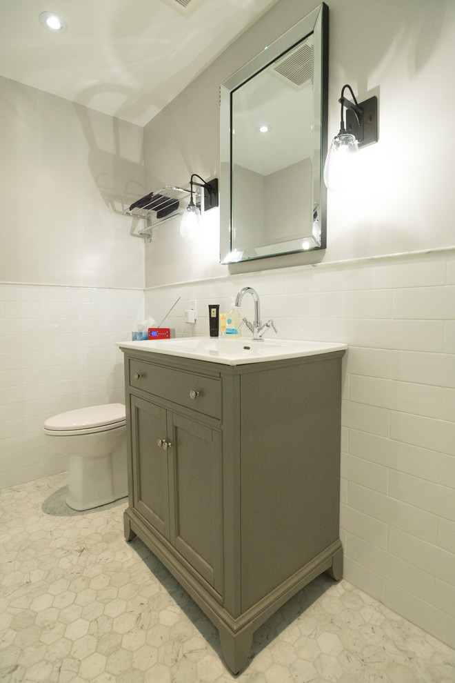 Small contemporary shower room bathroom in Toronto with shaker cabinets, green cabinets, solid surface worktops, a one-piece toilet, white tiles, metro tiles, grey walls, marble flooring, an alcove bath, an alcove shower, an integrated sink, beige floors and a hinged door.