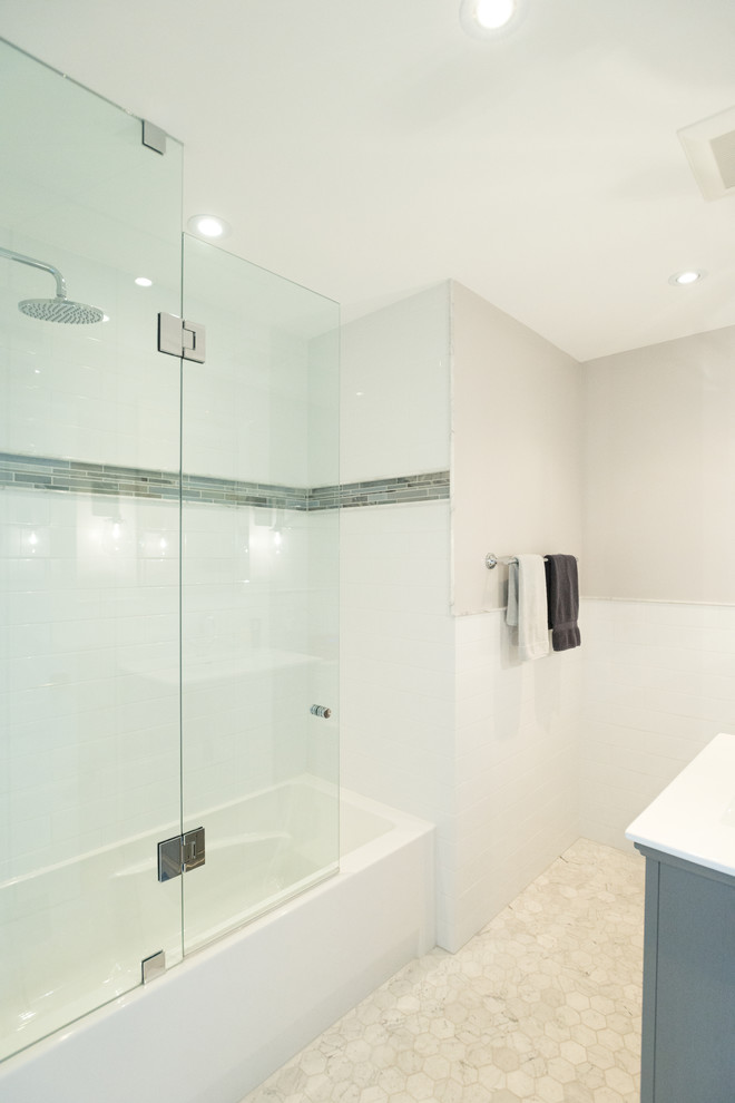 Design ideas for a small contemporary shower room bathroom in Toronto with an alcove bath, an alcove shower, white tiles, metro tiles, grey walls, marble flooring, blue cabinets, solid surface worktops, beige floors, a hinged door and an integrated sink.