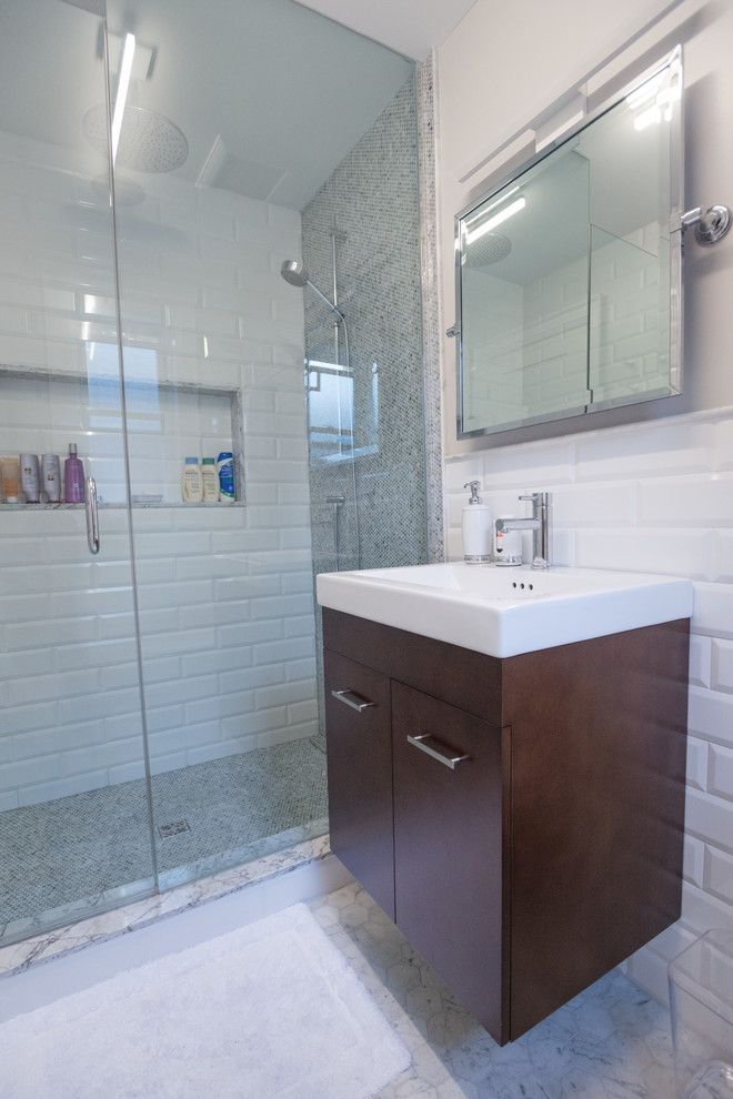 Inspiration for a small contemporary ensuite bathroom in Toronto with shaker cabinets, dark wood cabinets, solid surface worktops, a walk-in shower, white tiles, metro tiles, grey walls, marble flooring, an integrated sink, white floors and a hinged door.