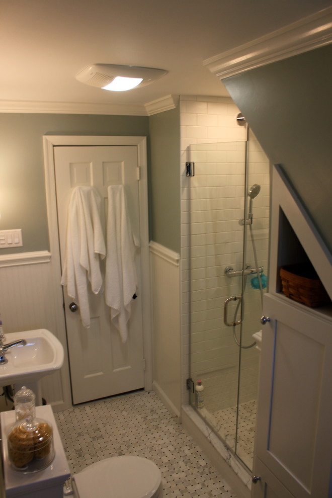 Photo of a medium sized traditional ensuite bathroom in Philadelphia with a pedestal sink, recessed-panel cabinets, white cabinets, an alcove shower, white tiles, metro tiles and marble flooring.