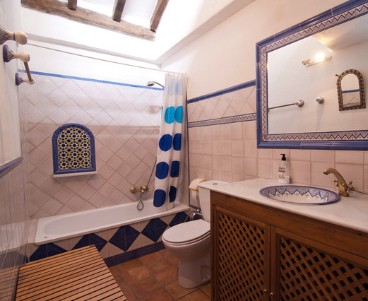 Idee per una stanza da bagno padronale costiera di medie dimensioni con pavimento in terracotta, vasca ad alcova, vasca/doccia, WC a due pezzi, pareti bianche e lavabo sottopiano