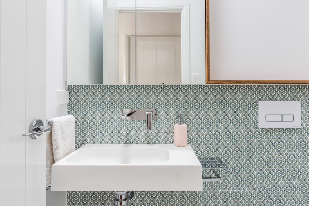 Пример оригинального дизайна: маленькая ванная комната в стиле неоклассика (современная классика) с плоскими фасадами, синими фасадами, накладной ванной, унитазом-моноблоком, синей плиткой, галечной плиткой, синими стенами, полом из цементной плитки, душевой кабиной, подвесной раковиной, столешницей из искусственного кварца, белым полом и белой столешницей для на участке и в саду