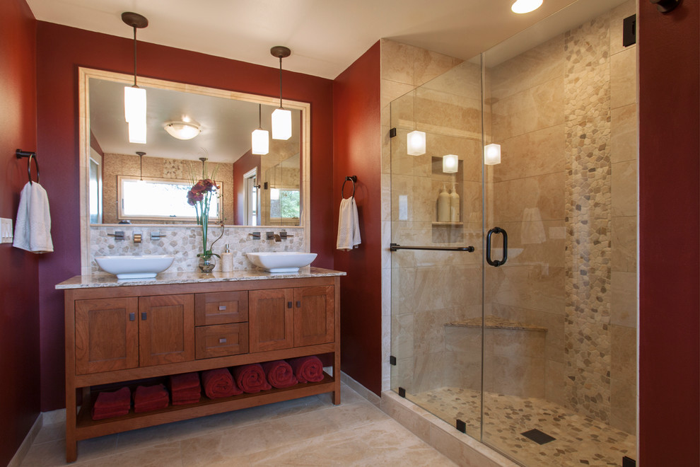 Cette image montre une douche en alcôve principale craftsman en bois brun de taille moyenne avec une vasque, un placard avec porte à panneau encastré, un plan de toilette en marbre, une baignoire indépendante, un carrelage beige, des carreaux de céramique, un mur rouge et un sol en carrelage de céramique.